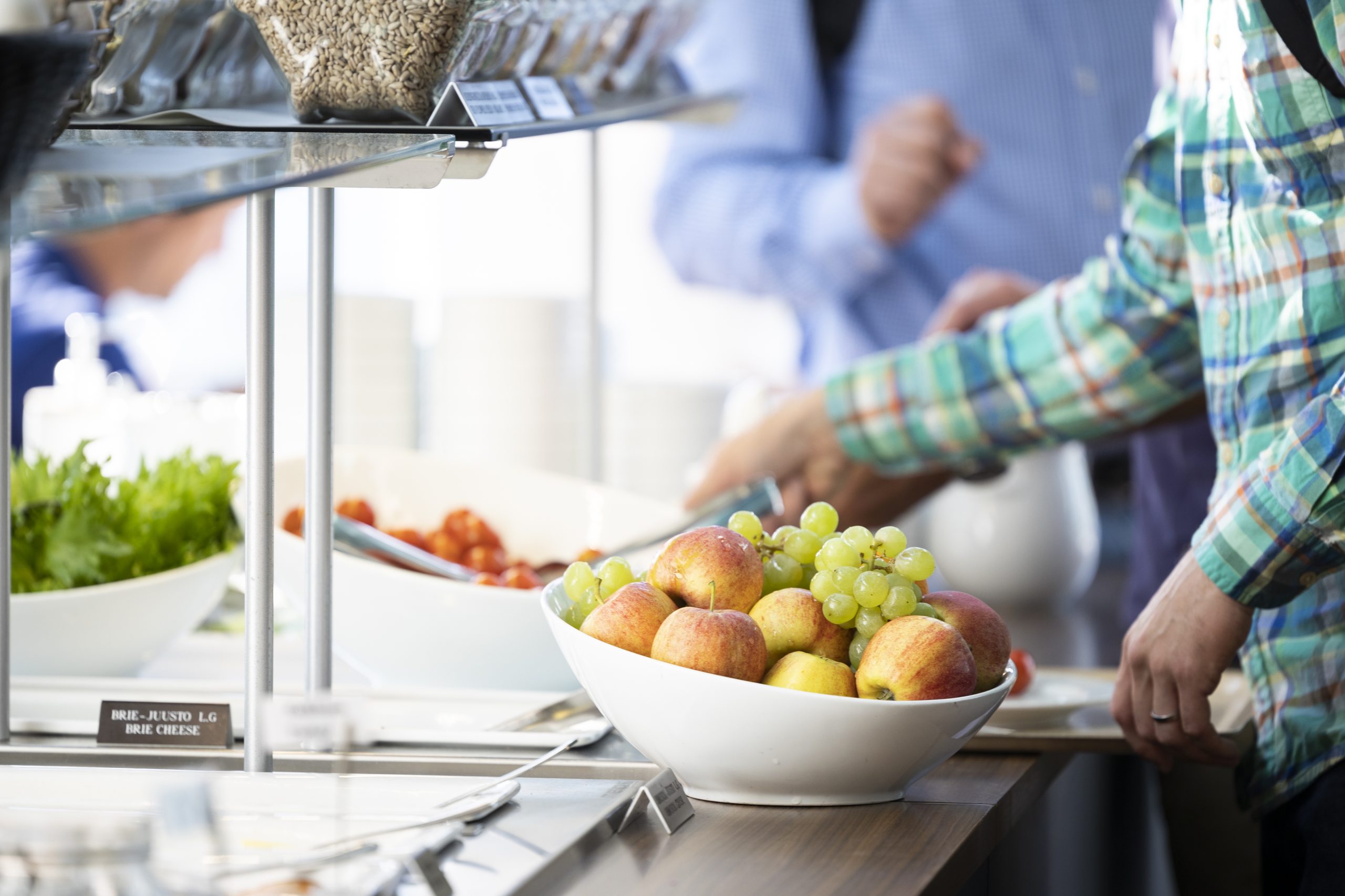 Henkilö ottamassa aamiaista buffet-linjastosta