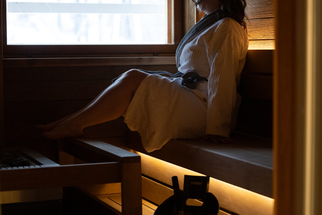 Nainen istuu saunan lauteella