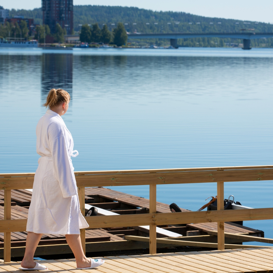 Nainen kävelee hotellin laiturilla aurinkoisena kesäpäivänä Jyväskylässä